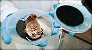 A silver silicon wafer reflects the face of NREL research scientist Hao-Chih Yuan, before the wafer is washed with a mix of acids. The acids etch holes, absorbing light and turning the wafer black. Credit: Dennis Schroeder
