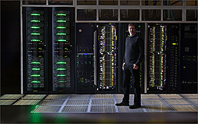 Steve Hammond, director of NREL's Computational Science Center, stands in front of air-cooled racks in the high performance computing (HPC) data center in the Energy Systems Integration Facility (ESIF). The rest of the system will be built out this summer using warm-water liquid cooling to reach an annualized average power usage effectiveness (PUE) rating of 1.06 or better. Credit: Dennis Schroeder