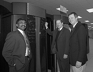 Gore signs in at the Cray computer as Thomas Zacharia and Jeff Wadsworth watch.