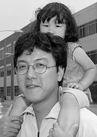 INTERNATIONAL COMMUNITY--Sawa Fujiwara, 2, gets a lift from her dad, Masatsugu, at August 27s Community Day.  Mom, Eri, works in the Metals & Ceramics Division. The Fujiwaras, who are from Japan, joined more than 4,000 visitors. More photos are found in the More than 4000 come to Community Day article.