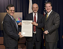 Illinois Department of Commerce and Economic Opportunity Director Jack Lavin (right) presents Argonne Director Robert Rosner (left) and Fermilab Director Pier Oddone with the Particle Accelerator Day proclamation.