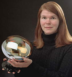 Columbia University's Janet Conrad holds one of the 1520 light sensors installed inside the MiniBooNE detector.