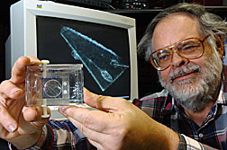 George Flynn of SUNY Plattsburgh displays a sample from the Stardust mission, analyzed at the Advanced Photon Source at Argonne.