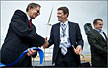 NREL's Deputy Laboratory Director Dana Christensen, left, shakes hands with Andy Geissbuehler, VP & General Manager of Alstom Power's Wind Business North America, at dedication ceremonies for the Alstom Eco 100 wind turbine. On the right is Steve Chalk, the Department of Energy's Deputy Assistant Secretary for Renewable Energy and Energy Efficiency. 