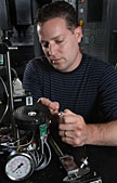 Sandia’s Jeff Koplow makes an adjustment to an earlier prototype of his Air Bearing Heat Exchanger invention. The technology, as known as the “Sandia Coole,” will significantly reduce the energy needed to cool the processor chips in data centers and large-scale computing environments. (Photo by Dino Vournas)