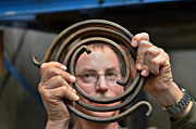 Elton Wright shows a torsional spring that’s used to simulate the rotational vibration of the drill string in a Sandia experiment. (Photo by Randy Montoya)