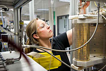 NREL Engineer Whitney Jablonski places a quartz reactor tube with a nickel-based catalyst into a reactor at NREL's Thermochemical Users Facility. Credit: Dennis Schroeder