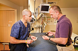 Albuquerque emergency room physician Scott Forman, left, and Sandia engineer Mark Reece look over a prototype set of improved trauma shears they worked on together. (Photo by Randy Montoya)
