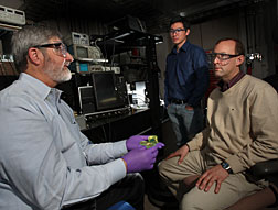 Sandia researchers Patrick Doty, Patrick Feng, and Mark Allendorf (L to R) have created a new type of scintillator using metal organic framework or plastic scintillator hosts combined with heavy metal dopants, shown in Doty’s hand. This material enables detection of neutrons using spectral- or pulse-shape discrimination techniques that could transform radiation detection (photo by Dino Vournas).