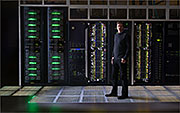 Steve Hammond, director of NREL's Computational Science Center, stands in front of air-cooled racks in the high performance computing (HPC) data center in the Energy Systems Integration Facility (ESIF). The rest of the system will be built out this summer using warm-water liquid cooling to reach an annualized average power usage effectiveness (PUE) rating of 1.06 or better. Credit: Dennis Schroeder