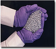 Scientist holding sorbents (pellets) in gloved hands.