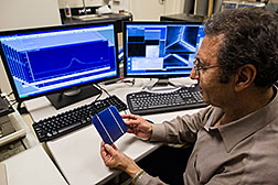 NREL Principal Scientist Mowafak Al-Jassim holds a TetraSun PV cell in the cathodoluminescence lab at NREL. The TetraSun cell combines increased efficiency and low cost, breaking the usual rules for solar cells. Credit: Dennis Schroeder