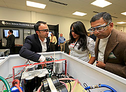 ORNL's Omer Onar demonstrates research in ORNL's Power Electronics and Electric Machinery lab to Andrea Gil of Clemson University and Ashok Moghe of Cisco Systems.
