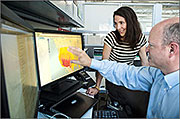 NREL's Nate Blair and Suzanne Tegen take a look at NREL's Solar Prospector tool, which provides information about the sun's resource potential at any spot in the nation. Industry is using models created by NREL to plan for renewable energy installations. Photo by Dennis Schroeder, NREL