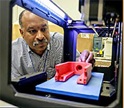 Bob Ellis with a 3D-printed plastic prototype for a non-mirror part of the launcher. (Photo credit: Elle Starkman/PPPL)