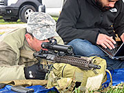 A member of the U.S. Army Special Forces, left, demonstrates the Rapid Adaptive Zoom for Assault Rifles prototype developed at Sandia National Laboratories.