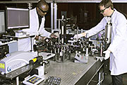 NETL researchers Christian Goueguel (left) and Cantwell Carson align and operate NETL’s laser induced breakdown spectroscopy (LIBS) equipment in a lab experiment.