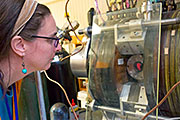 Lenore Rasmussen examines a titanium coupon used in her synthetic muscle as the metal is treated in an oxygen plasma at PPPL.