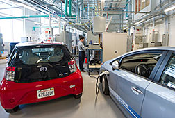 NREL Engineer Jiucai Zhang works on a vehicle grid integration project in the Smart Power Lab. The study connects electric vehicles and smart appliances to a grid in the lab to study the dynamics of how they interact. Photo by Dennis Schroeder, NREL