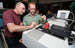 NREL researchers Ahmad Pesaran, left, and John Ireland work on a cell calorimeter at the Battery Testing Laboratory. Photo by Dennis Schroeder