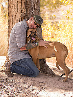 Rob Mitchell joined Sandia National Laboratories in 2013 as an environment, safety and health coordinator through the Labs’ Wounded Warrior Career Development Program, which makes certain Sandia jobs available to combat-wounded veterans temporarily, with the potential for permanent employment. He recently began bringing his service dog, Hunni, to work. (Photo by Steve Miller)