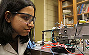 Ames Laboratory graduate student Eeshita Manna inspects an OLED array in the lab. She and other Ames Laboratory researchers created an all-organic UV on-chip spectrometer that can be used in a variety of applications for sensing and analysis.