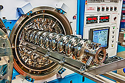 An LCLS-II-type accelerator cavity is inserted into a machine to be treated with nitrogen, a process that increases the cavity's quality factor. Photo credit: Fermilab