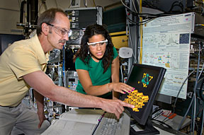 Brookhaven chemist Michael White and Melissa Patterson of Stony Brook review an image of a molybdenum sulfide nanocluster.