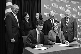 Happy outcome: Lab Director Thom Mason and NellOne Therapeutics CEO Tracy Warren (front row) sign the licensing agreement, observed by (back row, from left) Battelle’s Ron Townsend, Partnerships’ Jennifer Caldwell, researcher Bem Culiat, ORO Manager Gerald Boyd, and Partnerships Director Tom Ballard.