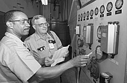 Craft Resources Divisions Reggie Thompson (left) and Herschel Brooks service an electrical panel. Facilities and Operations staff members have cut job request cycle times to nearly zero.