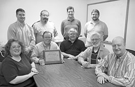Metrology Lab group members, shown with their hard-earned ISO 17025 plaque, are (standing, from left) Brian Sizemore, Bob Quinn, Joe Keck, Greg Strickland, (seated) Amanda Denton, Bob Effler, Wayne Holbert, Mike Day and Bill Wright.