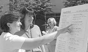 Programs such as Mays HealthFest are aimed at imrpoving the health and wellness of Lab staff. Karen Atchley (left) and Lori Muhs check out the months activities at an event emceed by ESH&Q Director Karen Downer.